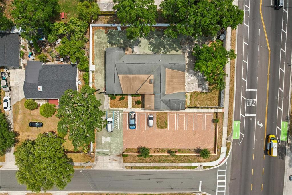 An aerial view shows a building with a parking lot and surrounding trees near a road — 1436 22ND STREET, ORLANDO, FL