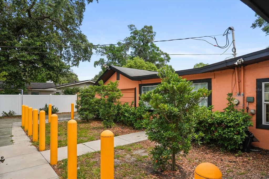 An orange exterior wall features a row of yellow bollards along a concrete walkway — 1436 22ND STREET, ORLANDO, FL
