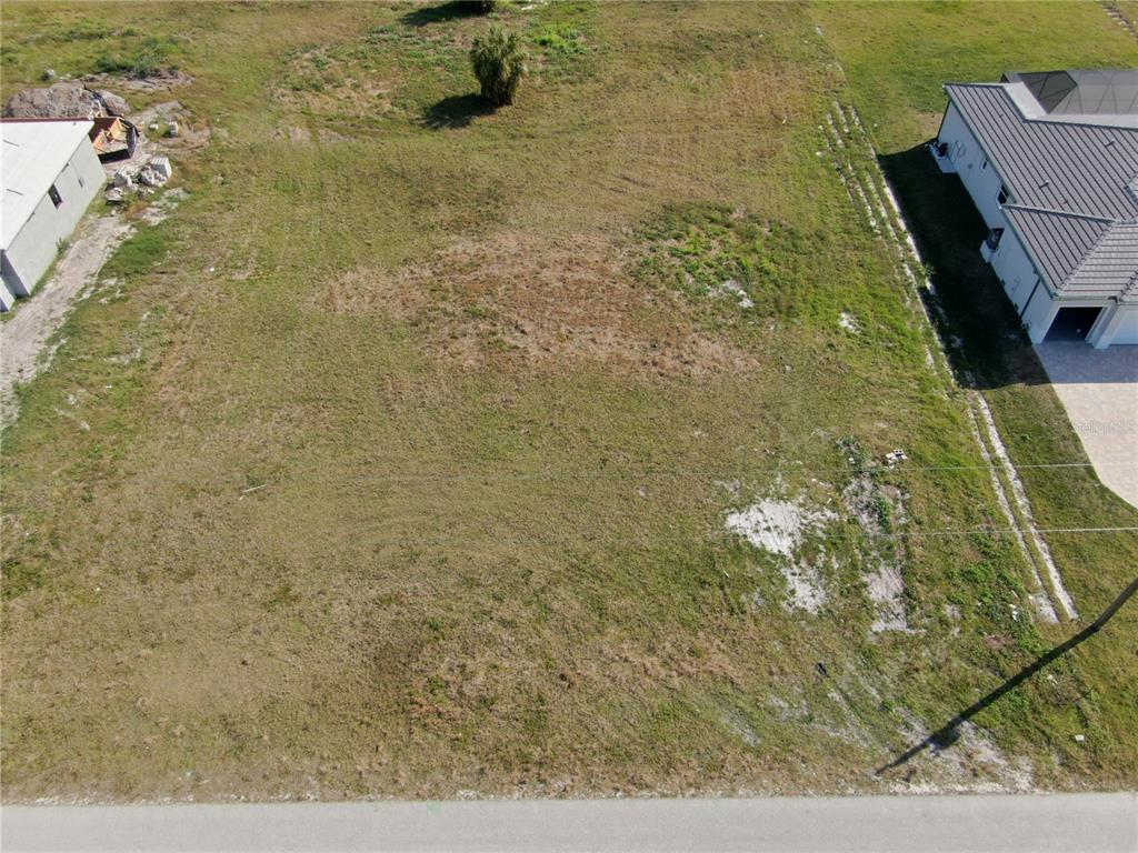 An aerial view shows a vacant, grassy residential lot situated between two existing houses — 191 ROTONDA BOULEVARD S, ROTONDA WEST, FL