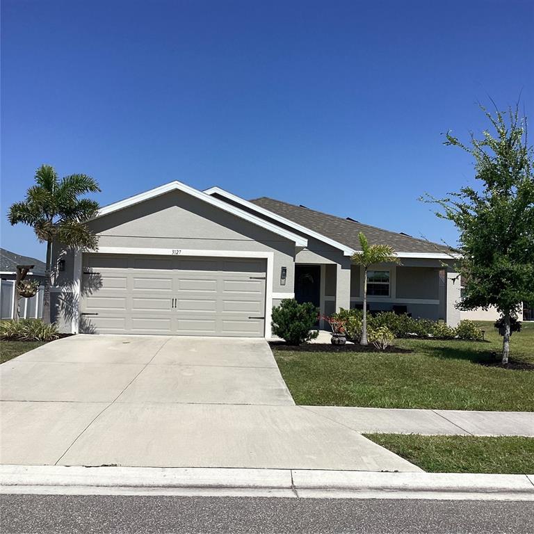 A single-story house with a gray exterior, a two-car garage, and a front porch — 3127 58TH WAY E, PALMETTO, FL