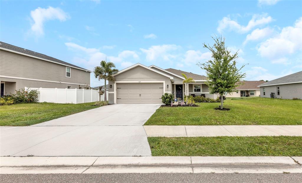 A single-story suburban house with a beige exterior, two-car garage, and a concrete driveway — 3127 58TH WAY E, PALMETTO, FL