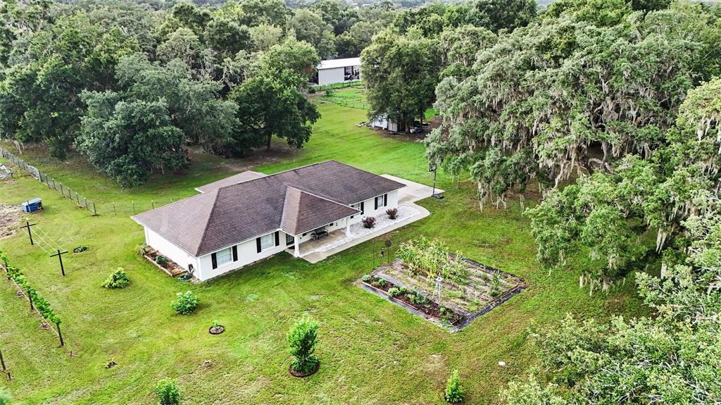 An open-concept living room, dining area, and kitchen with tile floors and vaulted ceilings — 7697 W C 476, BUSHNELL, FL