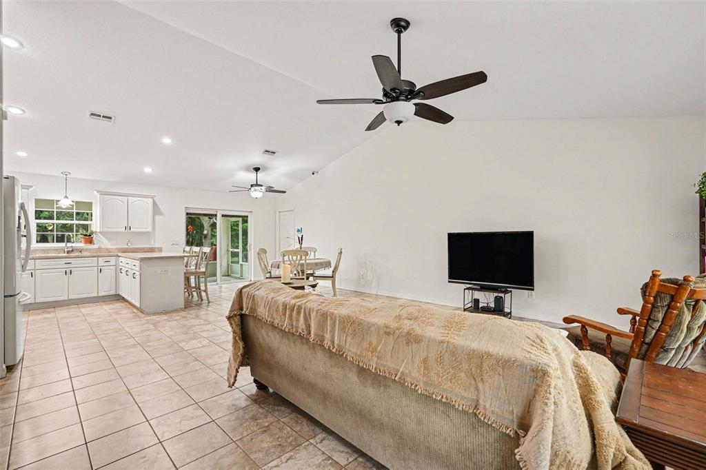 A kitchen with white cabinets, light countertops, a breakfast bar, and stainless steel appliances — 7697 W C 476, BUSHNELL, FL
