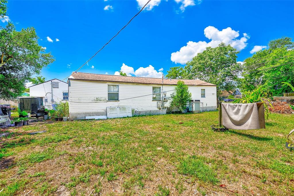 The exterior of a single-story white house with a backyard and a clothesline — 3257 57TH AVENUE N, ST PETERSBURG, FL