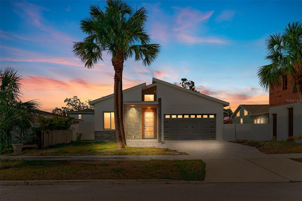 A modern single-story house with a stone-accented entryway, a garage, and a tall palm tree — 4907 15TH AVENUE N, ST PETERSBURG, FL