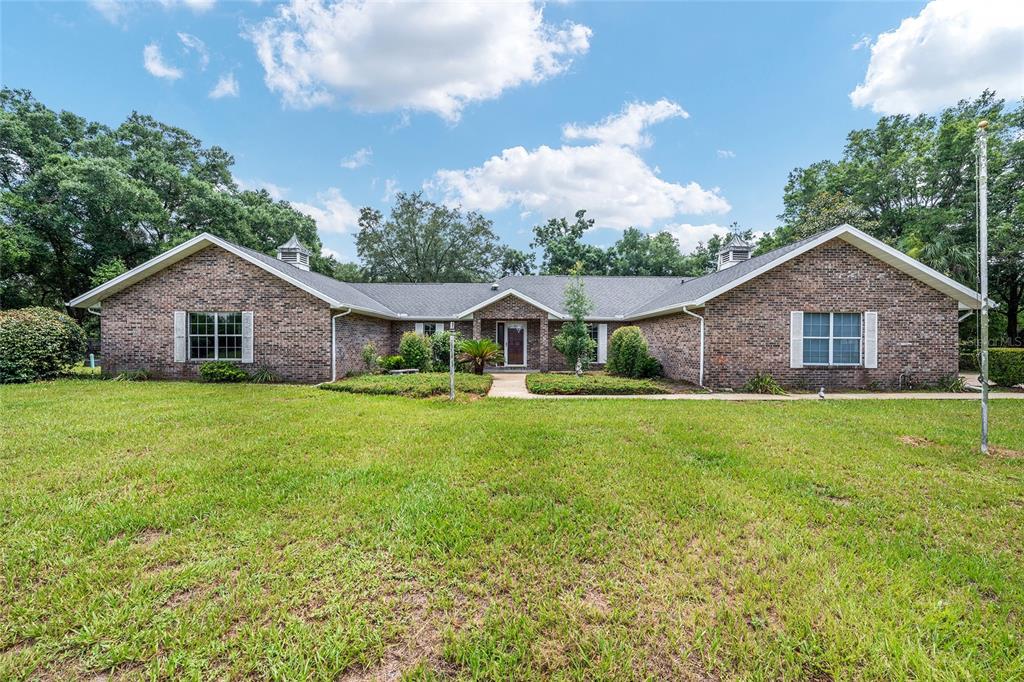 A single-story brick house with a gabled roof and a large front lawn — 6968 SW 99TH STREET, OCALA, FL