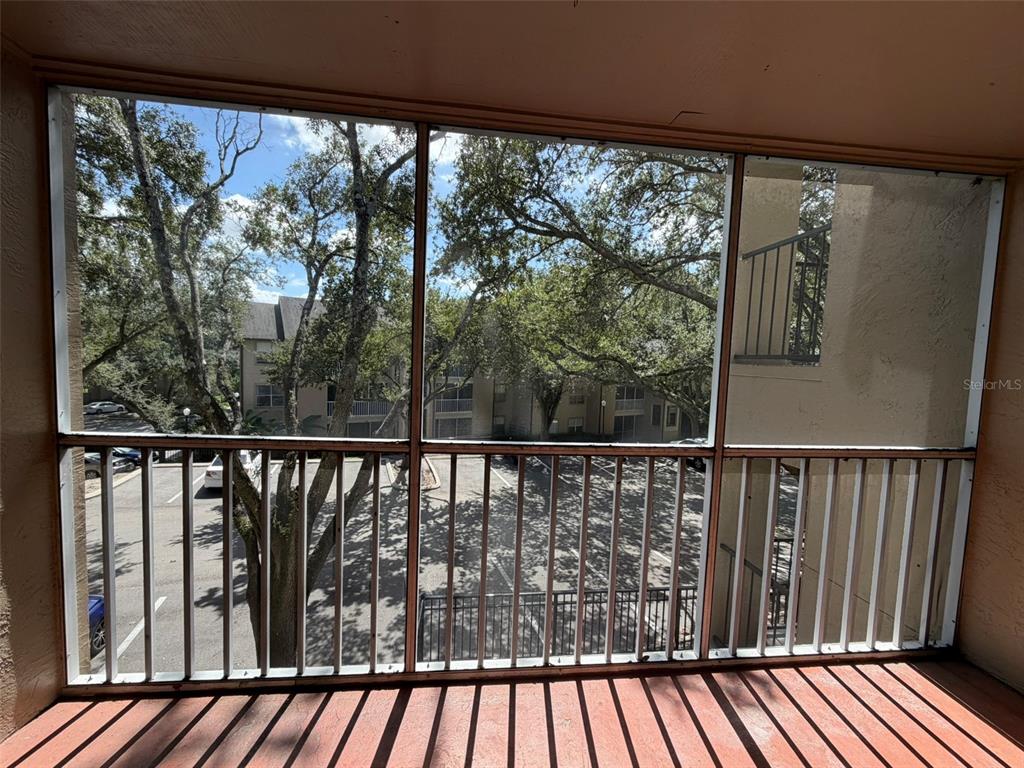 A screened-in balcony overlooks a parking lot and trees at an apartment complex — 974 LEEWARD PLACE UNIT 205, ALTAMONTE SPRINGS, FL