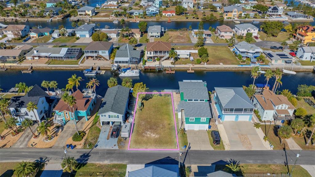 An aerial view shows a vacant, rectangular residential lot situated between two houses along a canal — 4029 CASA COURT, HERNANDO BEACH, FL