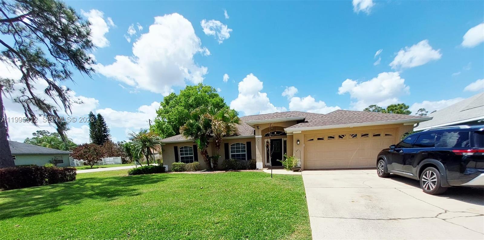 A single-story house with a tan exterior, a two-car garage, and a green lawn — 4031 Santa Barbara, Sebring FL 33875, SEBRING, FL