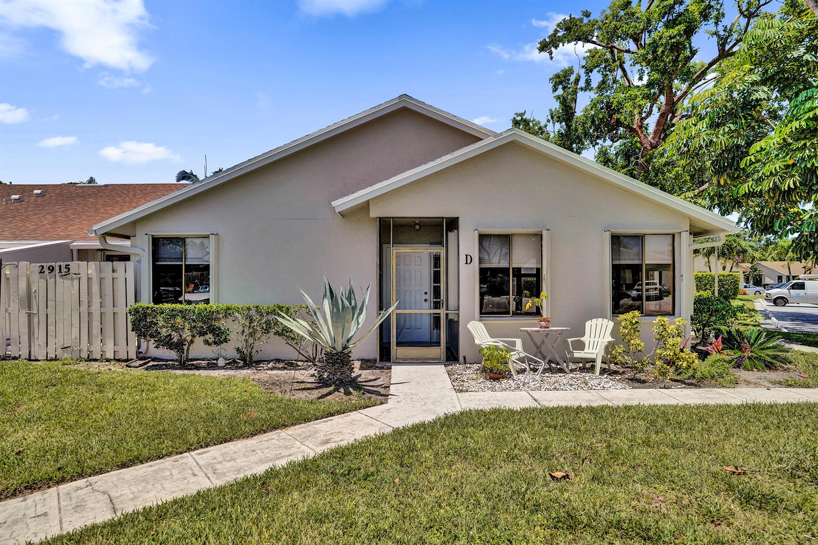 A single-story residential unit with a beige exterior, a front walkway, and a small patio — 2915 NW 12th Street # D, Delray Beach FL 33445, DELRAY BEACH, FL