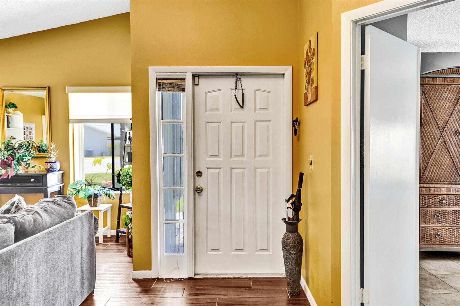 An entryway with a white front door, yellow walls, and a tall umbrella stand — 2915 NW 12th Street # D, Delray Beach FL 33445, DELRAY BEACH, FL