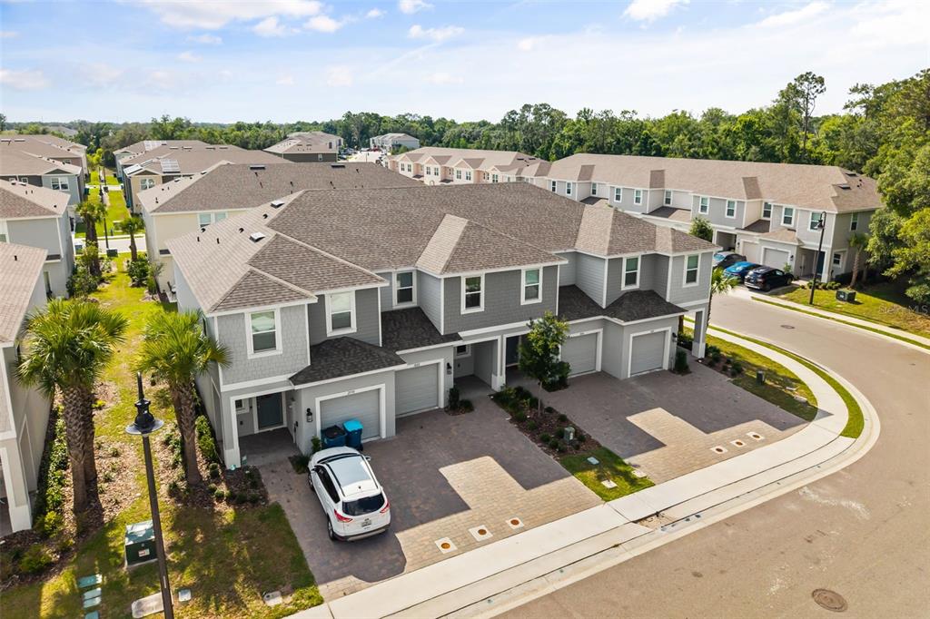 An aerial view shows a multi-unit townhouse complex with gray siding, shingled roofs, and driveways — 3002 CANARY AVENUE, DAVENPORT, FL