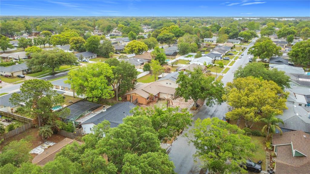 An aerial view shows a suburban neighborhood with single-family homes, mature trees, and paved streets — 5503 ALBERT DRIVE, WINTER PARK, FL