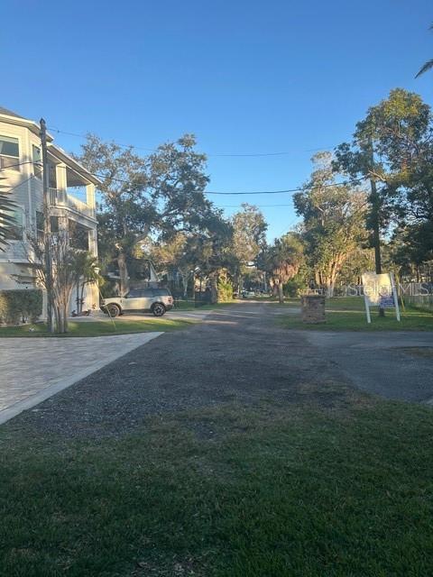 A gravel driveway leads toward a house and trees under a clear blue sky — 13311 72ND TERRACE N, SEMINOLE, FL