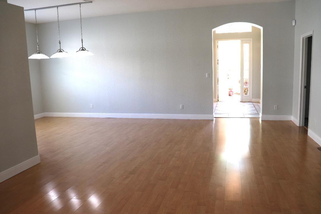 An empty dining area with light wood flooring, three pendant lights, and an arched entryway — 19298 Seneca Avenue, Weston FL 33332, WESTON, FL