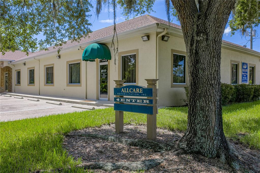 A single-story commercial building with a green awning and a sign for Allcare Rehabilitation — 1214 W REYNOLDS STREET UNIT 1, PLANT CITY, FL