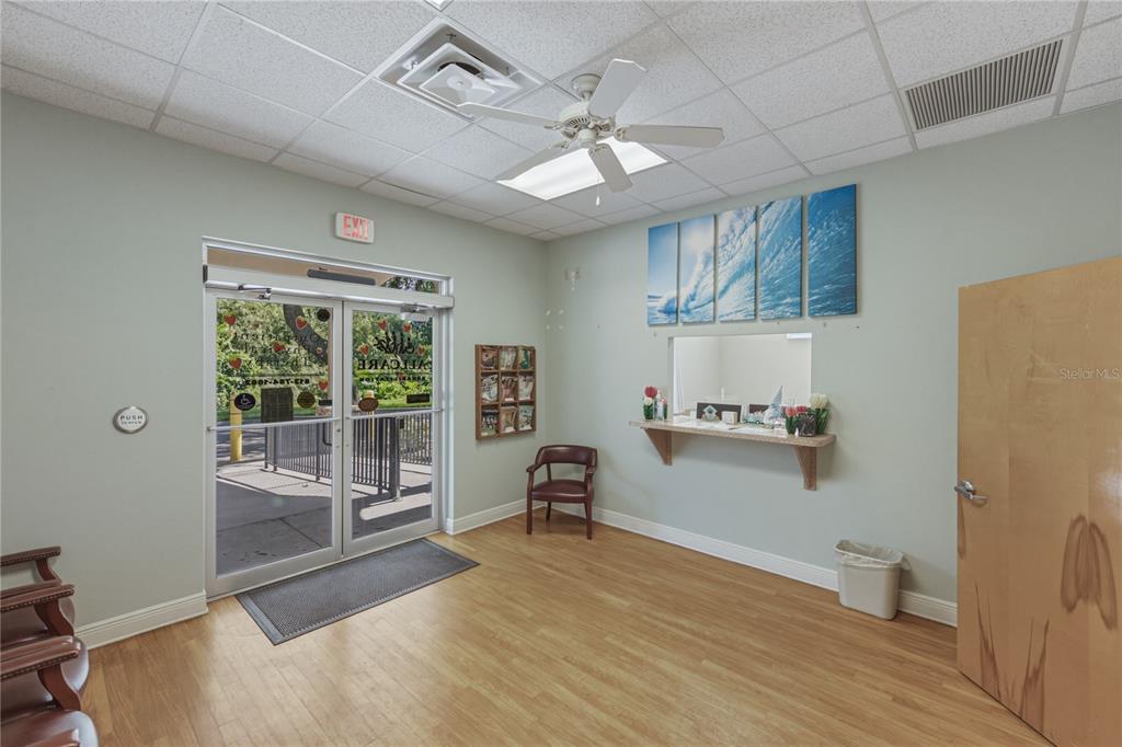 A waiting room features light wood flooring, a reception window, and a glass entry door — 1214 W REYNOLDS STREET UNIT 1, PLANT CITY, FL