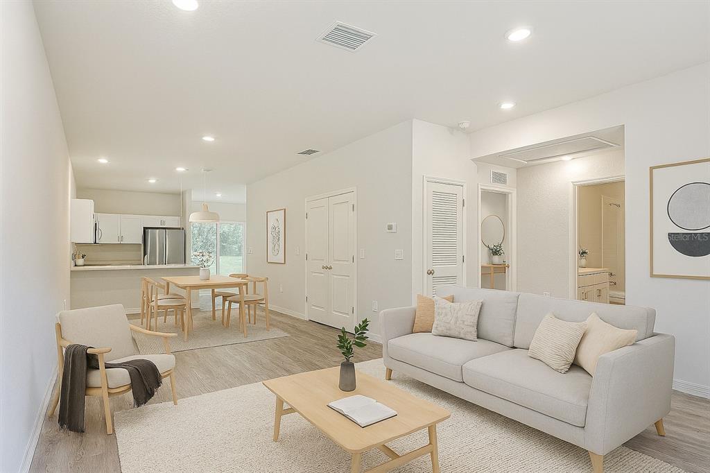 A bright, open-concept living and dining area features light wood flooring and neutral-toned furniture — 111 E HARVARD STREET, INVERNESS, FL