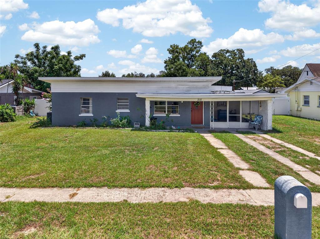 A single-story house with a gray exterior, a flat roof, and a front porch — 215 PALM AVENUE, AUBURNDALE, FL