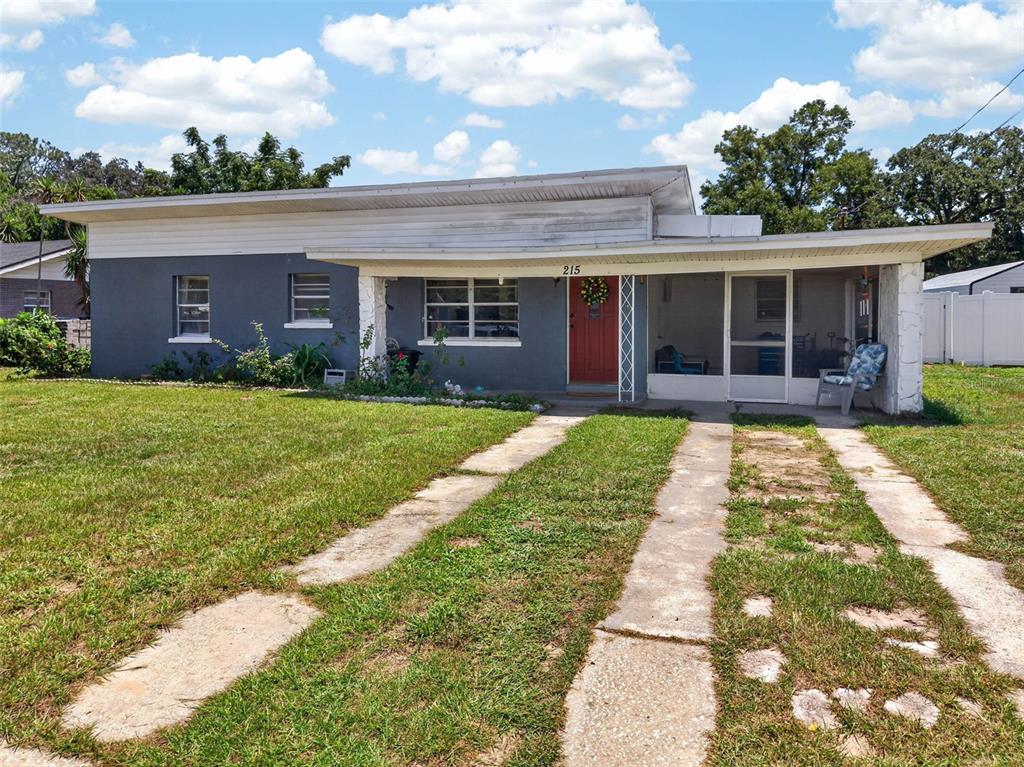 A single-story house with a gray exterior, a red front door, and a screened porch — 215 PALM AVENUE, AUBURNDALE, FL