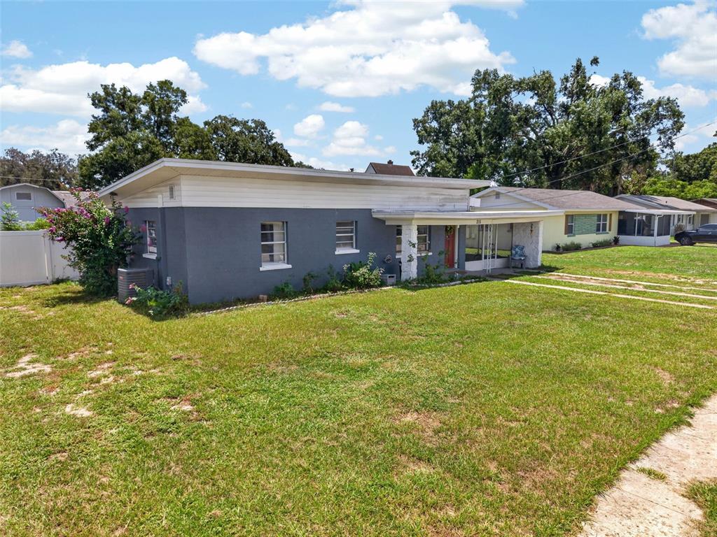 A gray, single-story house with a flat roof and a covered front porch — 215 PALM AVENUE, AUBURNDALE, FL