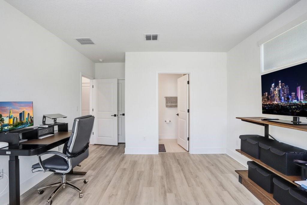 A home office with a desk, chair, television, and an open doorway to a bathroom — 2506 W CLEVELAND STREET UNIT 20, TAMPA, FL