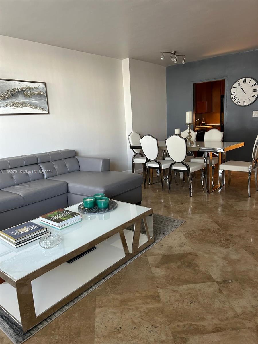 A living and dining area features a gray sectional sofa, glass coffee table, and dining set — 100 Lincoln Rd # 608, Miami Beach FL 33139, MIAMI BEACH, FL