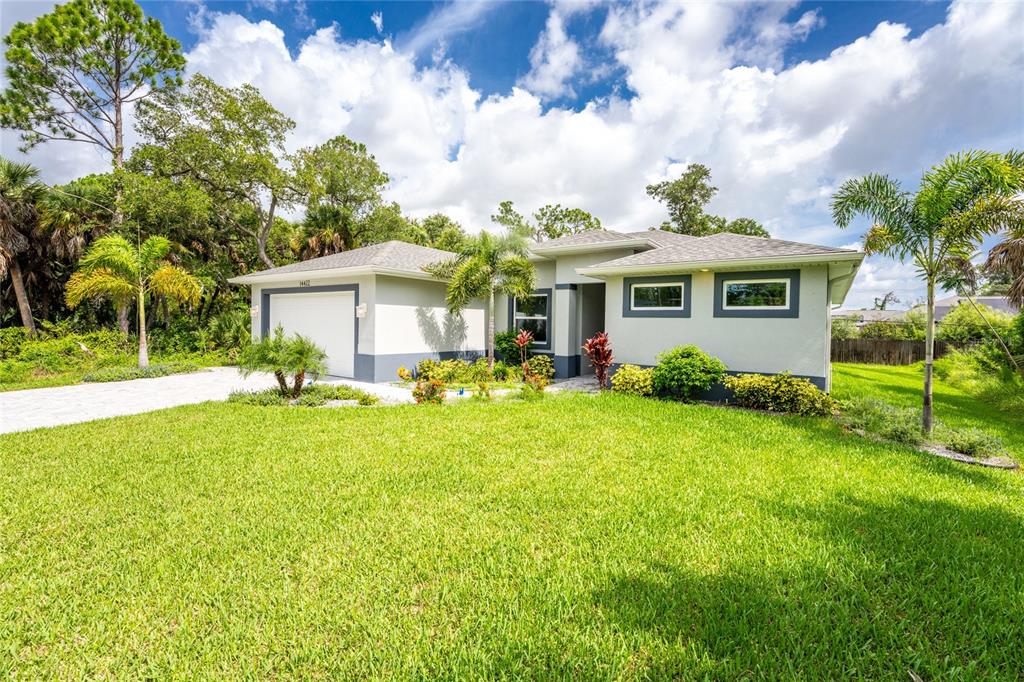 A single-story house with a white exterior, gray trim, and a green lawn — 14422 CHAMBERLAIN BOULEVARD, PORT CHARLOTTE, FL