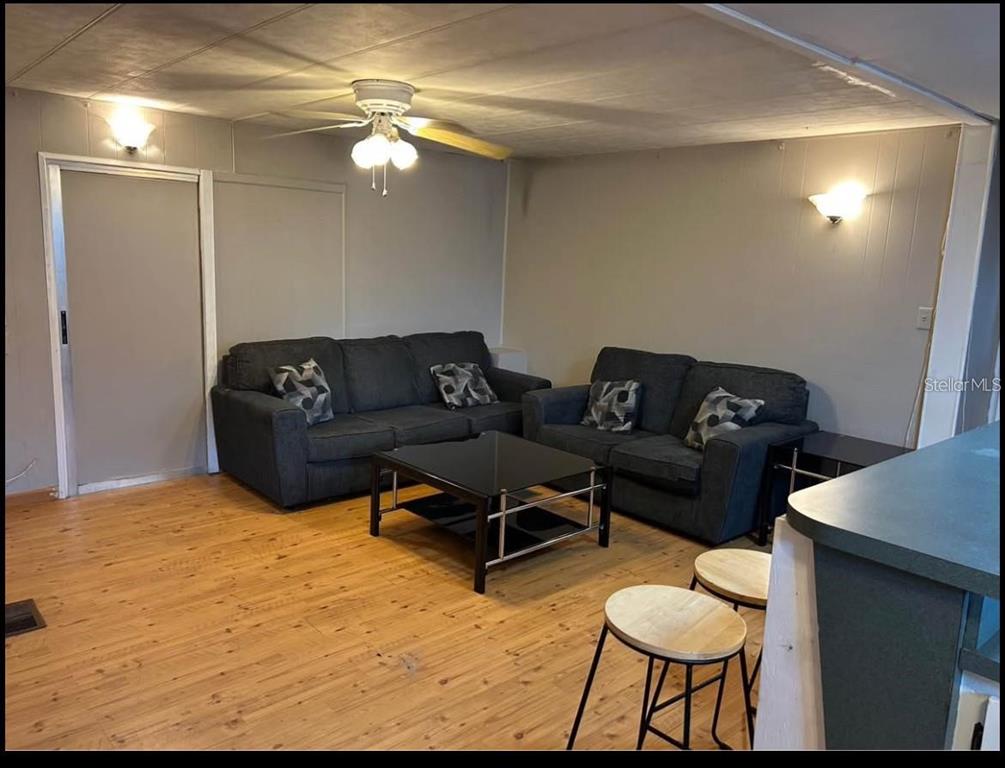 A single-story mobile home features a large concrete driveway and an attached covered carport — 5271 77TH STREET N, ST PETERSBURG, FL