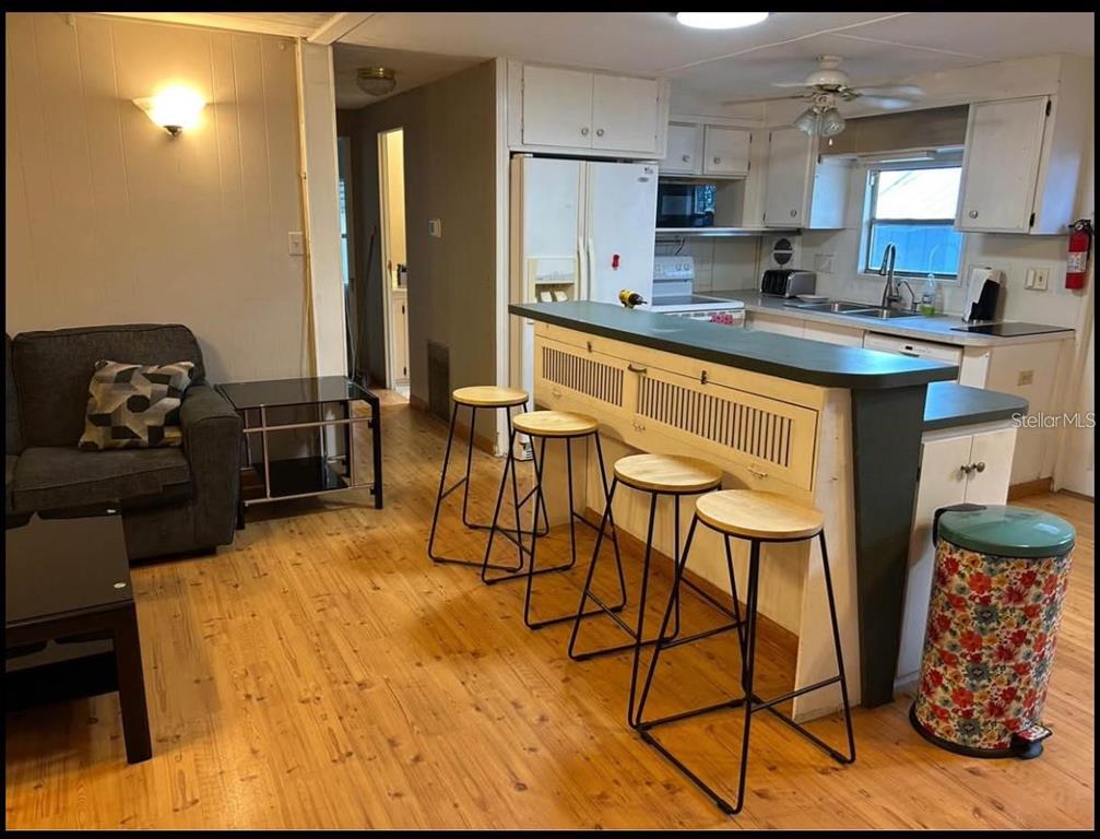 A single-story mobile home with a carport and a front yard sits along a street — 5271 77TH STREET N, ST PETERSBURG, FL