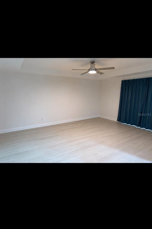 A spacious room with light wood-look flooring, white walls, and a ceiling fan — 507 PINECREST LOOP, DAVENPORT, FL