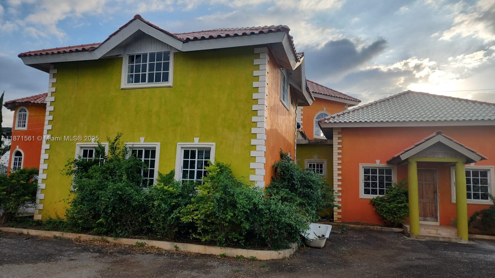 A two-story house with yellow and orange stucco walls and a tiled roof — 00 WILTSHIRE, TRELAWNY # 00, NA, NA