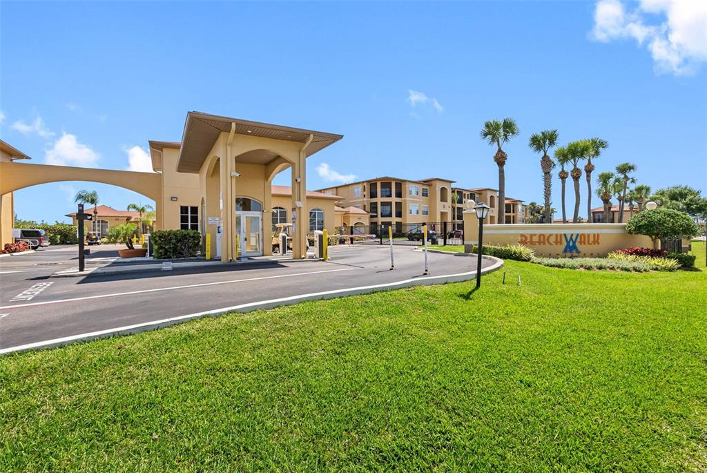 A gated entrance with a beige guardhouse and a sign reading Beachwalk — 4345 BAYSIDE VILLAGE DRIVE UNIT 302, TAMPA, FL