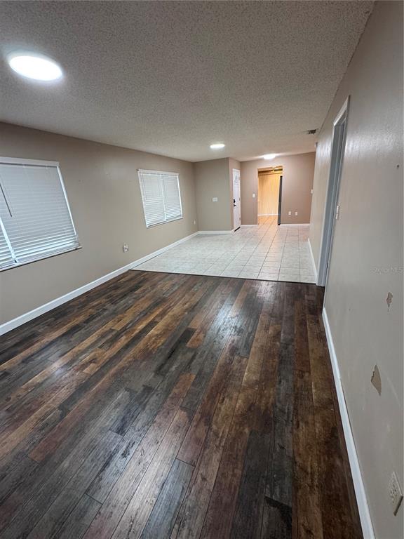 An interior view showing a living area with wood-look flooring transitioning to a tiled entryway — 511 LONGFELLOW COURT UNIT B, SAFETY HARBOR, FL