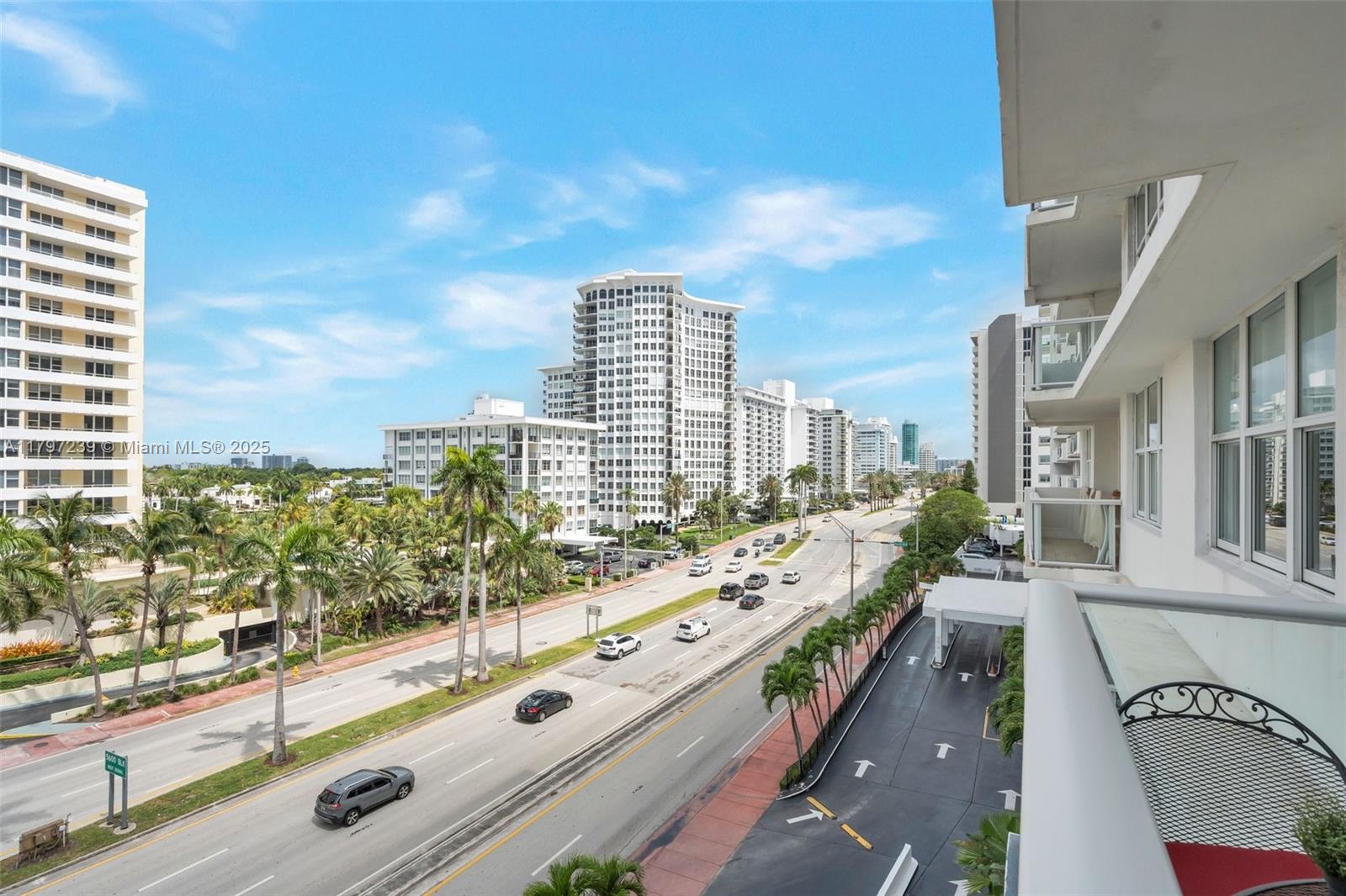 An elevated view from a balcony overlooking a multi-lane road and surrounding high-rise buildings — 5601 Collins Ave # 615, Miami Beach FL 33140, MIAMI BEACH, FL