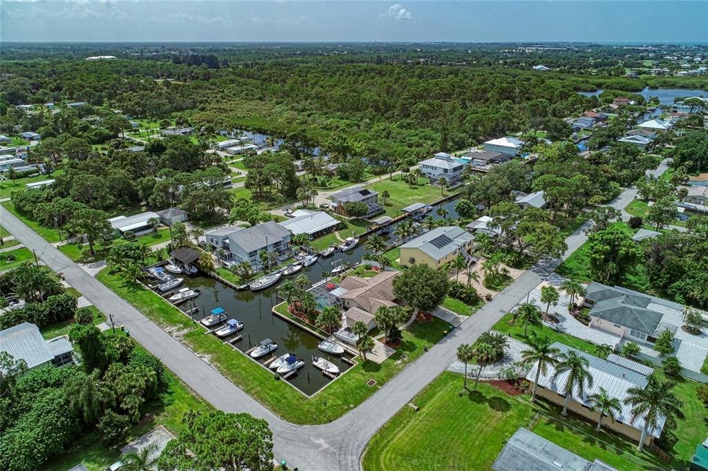 An aerial view shows waterfront homes with private boat docks along a canal — 9130 PINE COVE DRIVE UNIT B82, ENGLEWOOD, FL