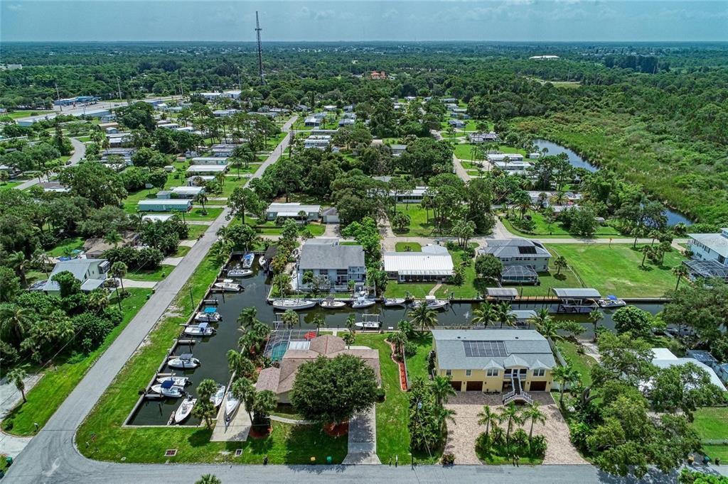 An aerial view shows waterfront homes with private boat slips along a canal — 9130 PINE COVE DRIVE UNIT B82, ENGLEWOOD, FL
