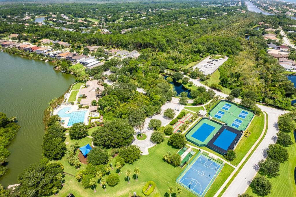 An aerial view shows a community recreation area with a swimming pool, tennis courts, and basketball — 78 N LAKEWALK DRIVE, PALM COAST, FL