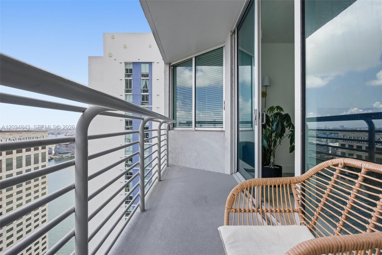 A balcony with a metal railing overlooks a city skyline and a nearby building — 325 S Biscayne Blvd # 4022, Miami FL 33131, MIAMI, FL