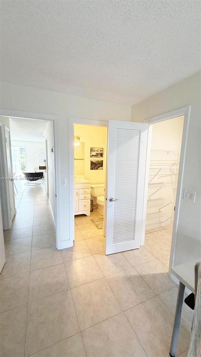 A hallway leads to a living area, a bathroom, and a walk-in closet with shelving — 2305 Lowson Blvd # B, Delray Beach FL 33445, DELRAY BEACH, FL