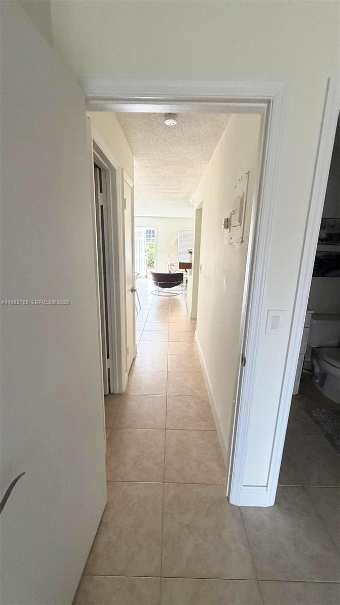 A tiled hallway leads from a doorway toward a living area with a chair — 2305 Lowson Blvd # B, Delray Beach FL 33445, DELRAY BEACH, FL