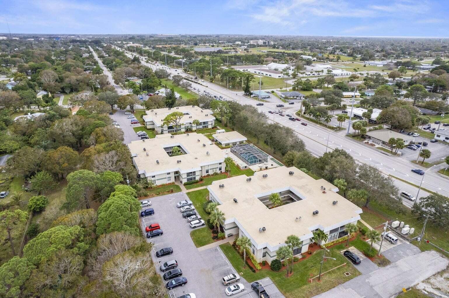 An aerial view shows three low-rise apartment buildings with central courtyards and surrounding parking lots — 2302 Sunrise Boulevard # 206, Fort Pierce FL 34982, FORT PIERCE, FL