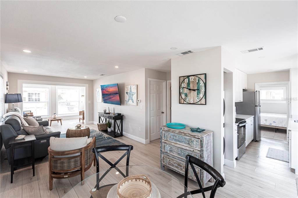 A living room and dining area feature light wood floors, neutral walls, and coastal decor — 6020 MIDNIGHT PASS ROAD UNIT 56, SARASOTA, FL