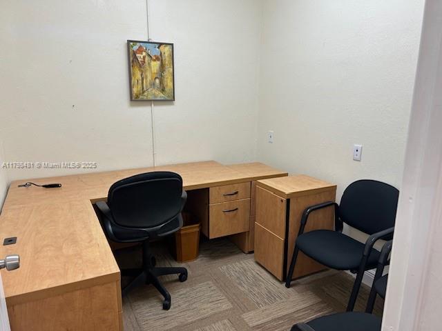 A small office features a light wood L-shaped desk, two black chairs, and wall art — 7601 Davie Road Ext, Davie FL 33024, DAVIE, FL
