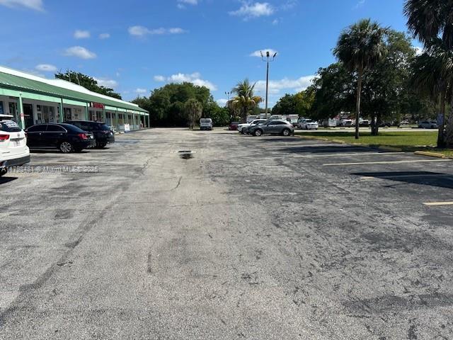 A parking lot sits in front of a single-story commercial building under a blue sky — 7601 Davie Road Ext, Davie FL 33024, DAVIE, FL