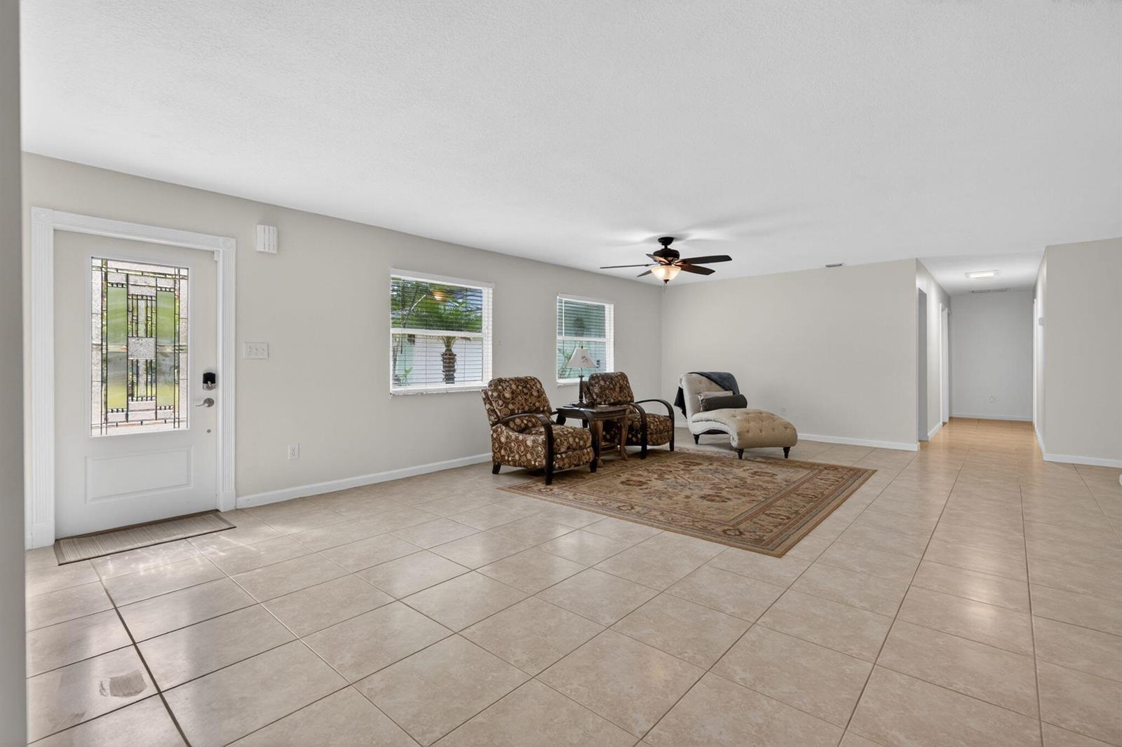 A living room with light tile floors, a ceiling fan, and a patterned area rug — 17391 Alexander Run, Jupiter FL 33478, JUPITER, FL