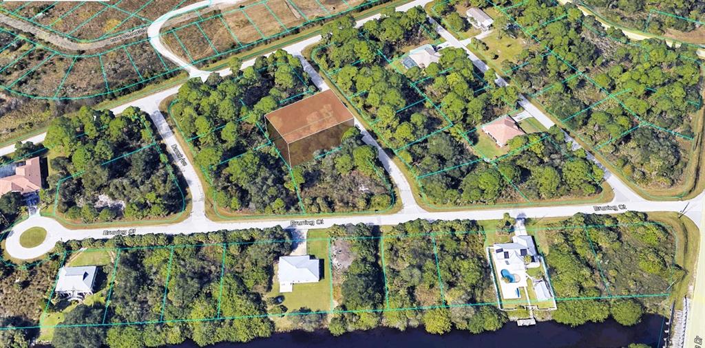 This aerial view shows a vacant, wooded residential lot highlighted in a suburban neighborhood — 15297 CASTO AVENUE, PORT CHARLOTTE, FL
