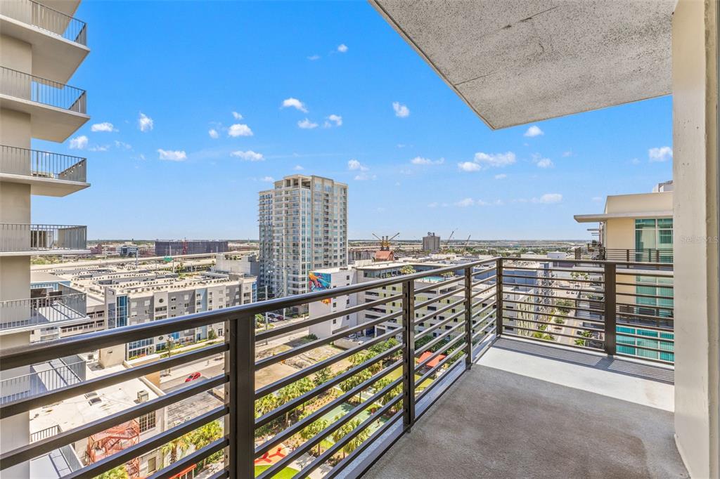 A modern living room features a grey sofa, two armchairs, a coffee table, and floor-to-ceiling windows — 1120 E KENNEDY BOULEVARD UNIT 1229, TAMPA, FL