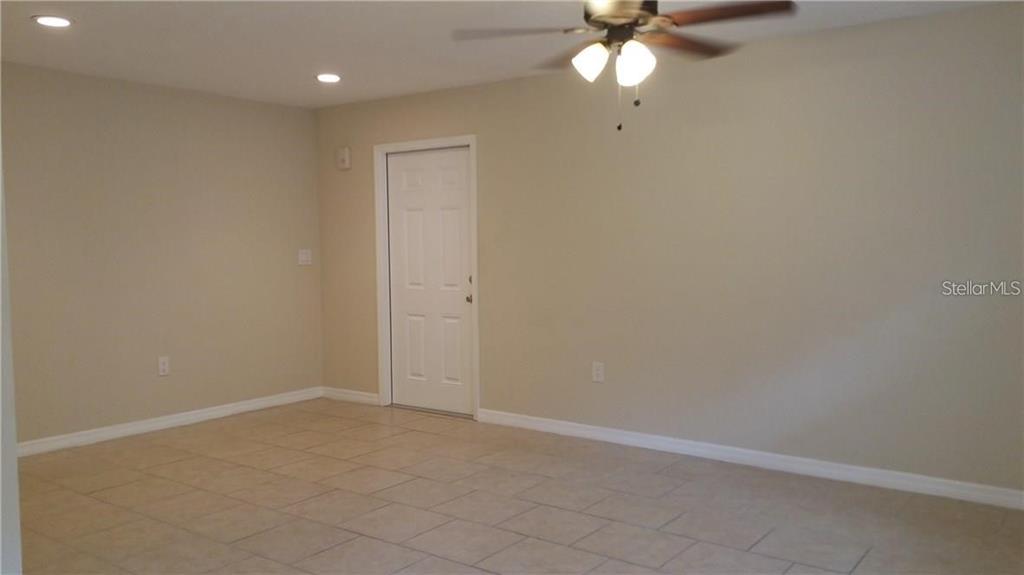 A dining area features a chandelier, tiled floors, and a window with white blinds — 1856 DEBBIE STREET Unit A, SARASOTA, FL