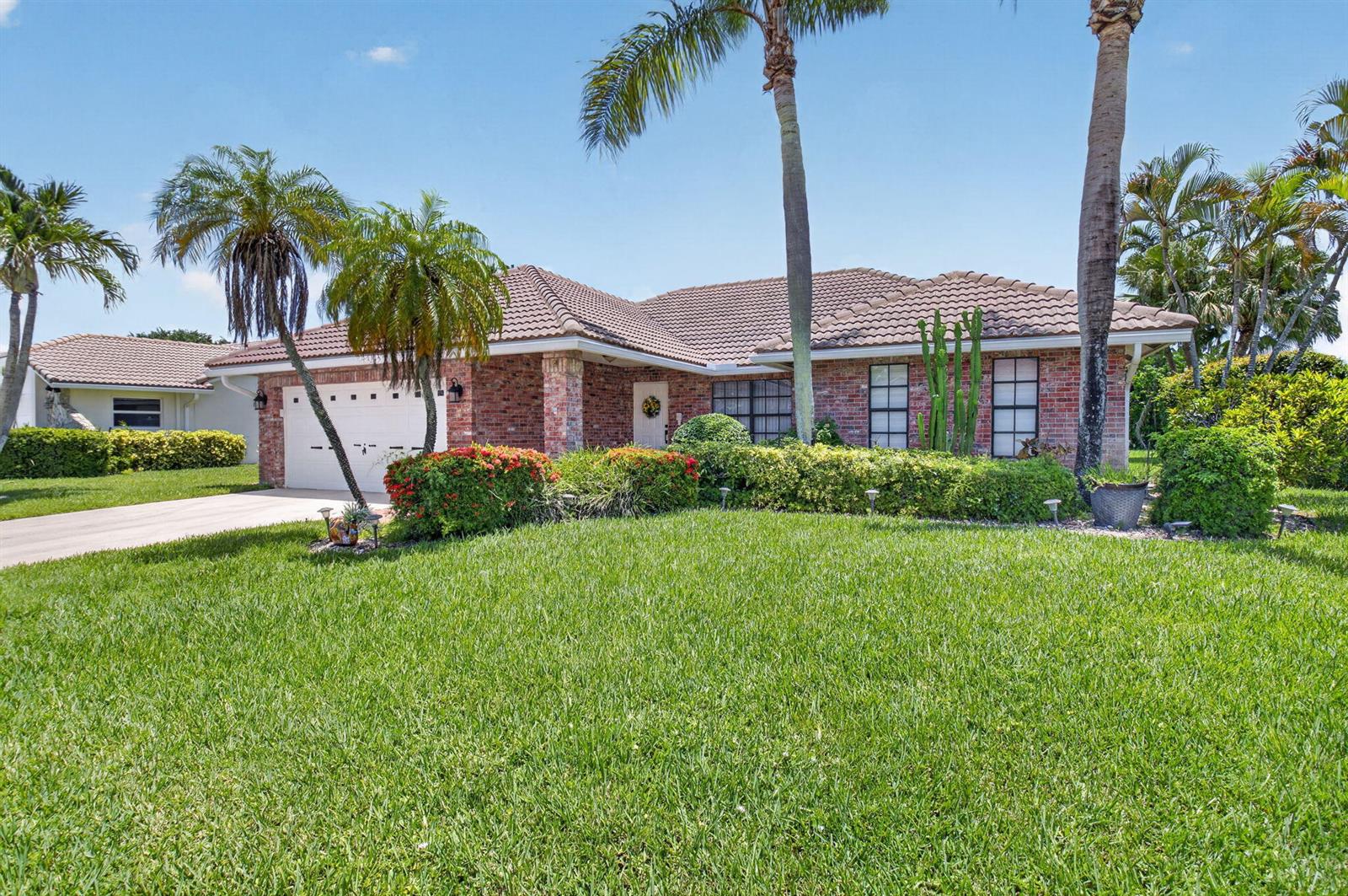 A single-story brick house with a tile roof, palm trees, and a manicured lawn — 19600 Sedgefield Terrace, Boca Raton FL 33498, BOCA RATON, FL